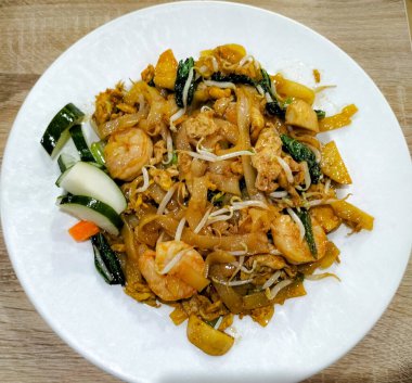 Seçici odaklanma. Kwetiaw ya da Kwetiau manzarası. Köfteli ve sebzeli kızarmış pirinç eriştesi. Kızarmış kwetiau tipik bir Endonezya Çin yemeğidir. Endonezya 'da popüler.