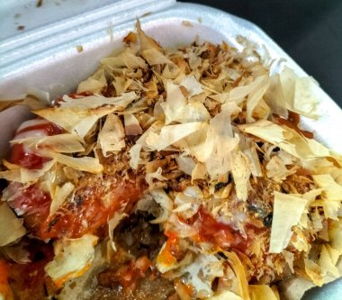 Takoyaki yemeğinin lezzeti. Beyaz köpük ambalajlı Takoyaki yemeği. Seçici odak.