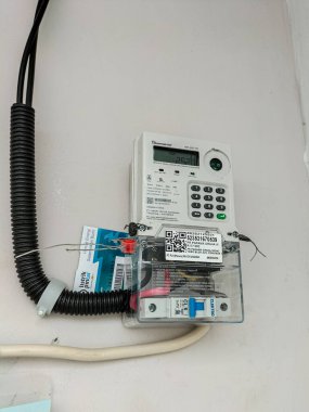 Evin duvarına eklenmiş bir Jeton ya da Kredi Sistemi ile Elektrik Taksimetrelerinin yakın görüntüsü. Endonezya 'da sübvansiyonlu konut. Hükümet programı. 