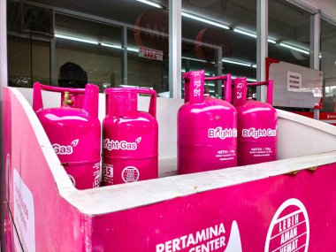 Seçici odaklanma. Bringht Store 'da 55kg ve 12kg ağırlıklı parlak gaz LPG silindiri pembe renk satıldı. Semarang - Endonezya.
