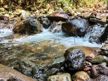 Seçici odaklanma. Su, Semarang Regency 'deki dereden şiddetli bir şekilde akıyor..