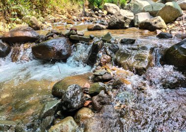 Seçici odaklanma. Su, Semarang Regency 'deki dereden şiddetli bir şekilde akıyor..