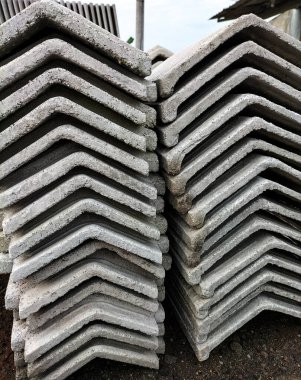 Çatı kaplaması için beton üçgen bloklar yığını. Bina korunuyor. Seçici odak. 