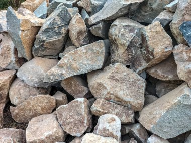 Yan görüş. Taş yığını. Temel inşa etmek için kaya taşları. Seçici odak.