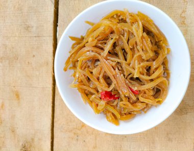 Seçici odaklanma. Kızarmış taze papaya dilimlerinin tadı baharatlı ve lezzetli. Papaya meyvesi arpacık soğanı, sarımsak ve biberle pişirilir..