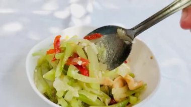 Endonezya 'da dilimlenmiş karides köfteli sotelenmiş balkabağı ve beyaz bir kâse üzerinde Tumis labu siam adı verilen kızarmış chayote sebzeleri. Lezzetli Endonezya mutfağı.