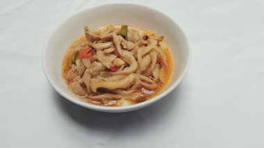 Beyaz arka planı olan beyaz bir kasede kızartılmış mantar videosu. Sağlıklı sebzeler. Sotelenmiş mantar geleneksel bir Endonezya yemeğidir. Yemek fotoğrafçılığı.