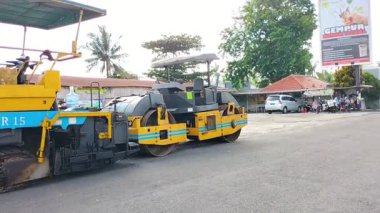 Halka açık sokak işleri için ağır inşaat makineleri ve kamyonet manzarası. Modern inşaat makineleriyle yol döşeme işlemi. Endonezya.
