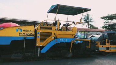 Halka açık sokak işleri için ağır inşaat makineleri ve kamyonet manzarası. Modern inşaat makineleriyle yol döşeme işlemi. Endonezya.