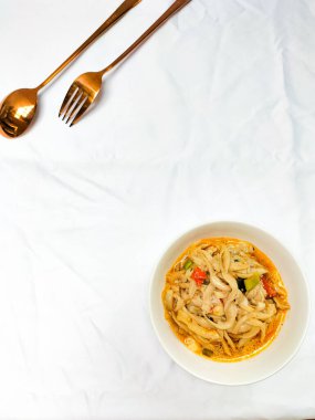 Seçici odaklanma. Karıştırılmış istiridye mantarı ya da midye reçeli tiram. Tadı daha taze olsun diye domatesle servis ediliyor ve beyaz arka planlı beyaz bir kasede servis ediliyor. Kaşık ve çatal..