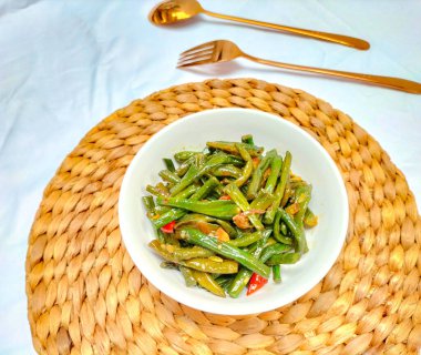 Seçici odaklanma. Karıştırılmış Uzun Fasulye, karışık sebze ve sebze karışımı ile kızartılmış bir sebze yemeği. Beyaz bir kasede servis edildi..