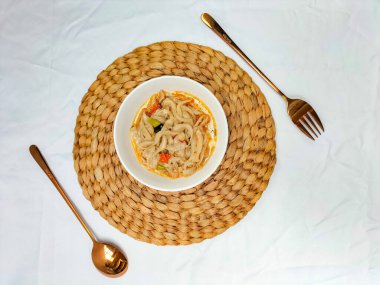 Seçici odaklanma. Karıştırılmış istiridye mantarı ya da midye reçeli tiram. Tadı daha taze olsun diye domatesle servis ediliyor ve beyaz arka planlı beyaz bir kasede servis ediliyor. Kaşık ve çatal..