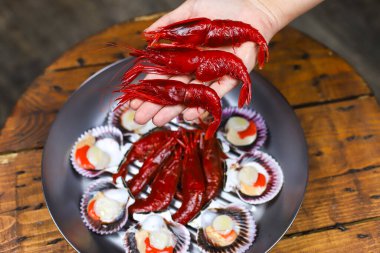 Tavada ve elde servis edilen İspanyol deniz ürünleri, kırmızı karides Camarones Rojo ve istiridye Zamburinas.