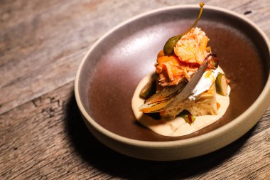 Tütsülenmiş somon, beyaz sebzeli püre ve karamelize arpacık soğanlı foksitler.