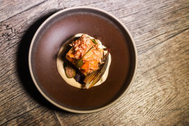 Tütsülenmiş somon, beyaz sebzeli püre ve karamelize arpacık soğanlı foksitler.