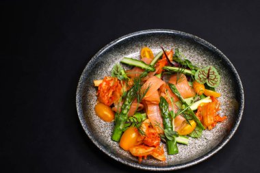 Pişmiş somon, kuşkonmaz ve kimchi soslu salata.