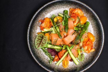 Pişmiş somon, kuşkonmaz ve kimchi soslu salata.