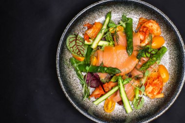 Pişmiş somon, kuşkonmaz ve kimchi soslu salata.