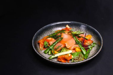 Pişmiş somon, kuşkonmaz ve kimchi soslu salata.
