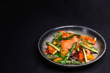Pişmiş somon, kuşkonmaz ve kimchi soslu salata.