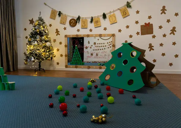 Play room with lit up Christmas tree and wall decorations