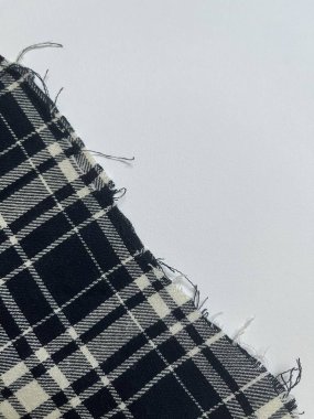 Siyah ve beyaz ekose kumaşın yıpranmış kenarı