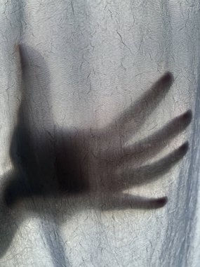 Perdenin arkasındaki kişinin gölgesi.