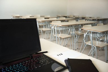 Resepsiyonda dizüstü bilgisayarı ve tableti olan boş bir sınıf