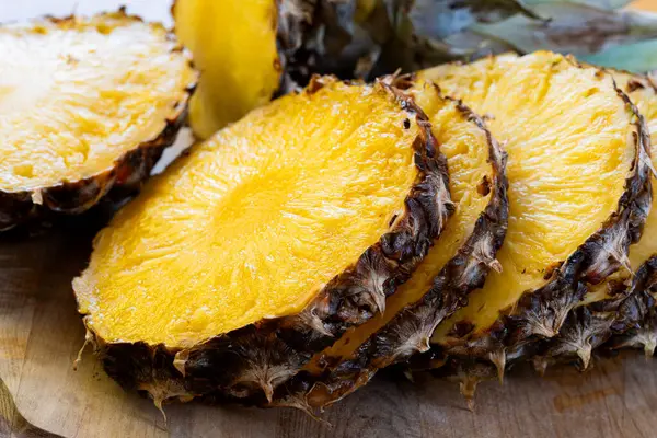 slices of pineapple on a wooden table, close up