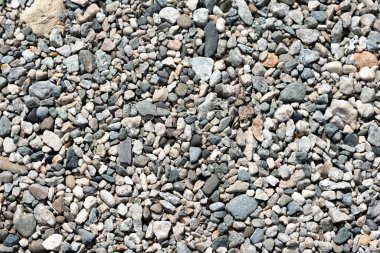 Çakıl taşları ve kum okyanus duvar kağıdı arka planında.