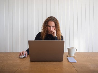 Zencefilli genç bir kadının bir fincan çayla uzaktan yakından ilgilenmesi.