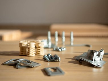 Masada düzgünce düzenlenmiş vida, panel ve metal parantez, mobilya montajı için hazır.