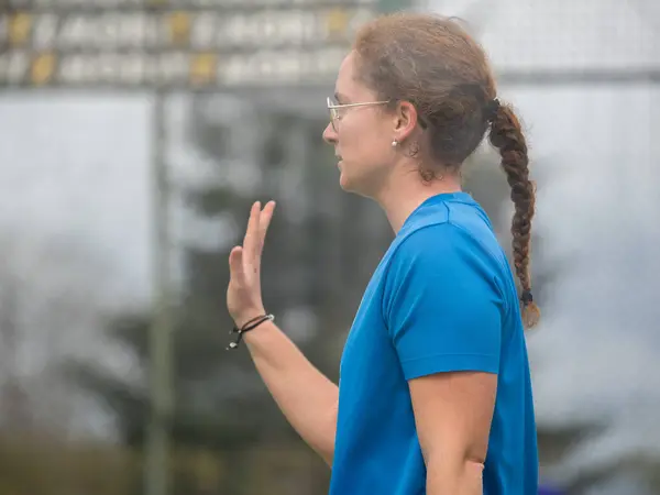 Çiftler maçında el işareti yapan odaklanmış bir kadın Padel oyuncusunun yan görünümü