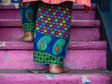 Çıplak ayaklı yaşlı bir Hindu kadın, Malezya 'daki Batu Mağaraları' nda canlı pembe adımlarla yükselir. Bu, derin ruhani bağlılık ve kültürel geleneği temsil eder.