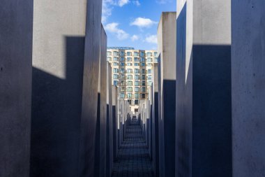 Berlin, Germany - September 14, 2024: Pathway Through Holocaust Memorial with Building View. clipart