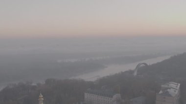 Kyiv, Ukrayna. Bir İHA 'dan ateş etmek. Havadan ateş ediyorlar. Şehrin merkezi ve Dinyeper Nehri 'nin manzarası. Sabahın erken saatlerinde. Güneşli şafak. Harika kalite 4K. Şehir manzarası. Sonbahar manzarası. 