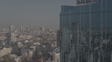 Güneşli bir günde drone görüntüleri. Kyiv. Aynalı camları olan büyük bir iş merkezi. Kalite 4K. Şehrin yansıması iş merkezinin aynalı camlarında
