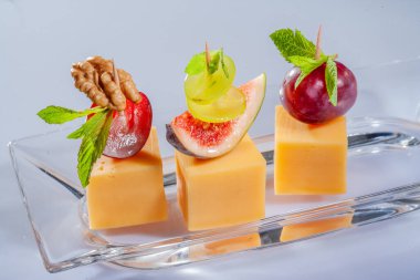 Peynir ve meyveli çeşitli peynir kompozisyonları. Farklı dokulara ve renklere sahip sert peynir. Çeşitli tipte sert peynirler. Meyveli küçük peynir parçaları.