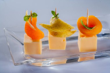 Peynir ve meyveli çeşitli peynir kompozisyonları. Farklı dokulara ve renklere sahip sert peynir. Çeşitli tipte sert peynirler. Meyveli küçük peynir parçaları.