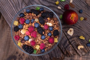 Fresh wild berries and nuts. Berries and granola on a wooden table. Healthy breakfast. Healthy food. View from above.