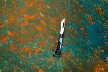 Tourist folding knife. Knife with whistle and serrated blade. French pocket knife. View from above.