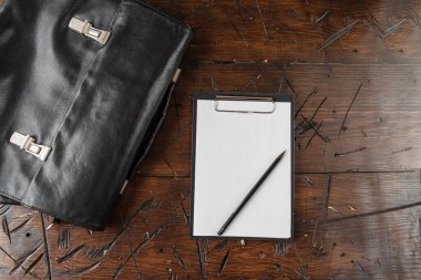 White sheet of paper and black pencil. Tablet with a sheet of paper and a pencil. Leather briefcase and tablet with a blank sheet.