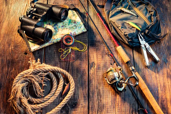 リールラインで回転する釣り 木製の背景に釣りアイテム 双眼鏡とロープ — ストック写真