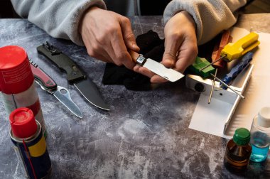 Bıçağı bilemek ve onunla ilgilenmek. Keskinlik için bıçağı kontrol ediyorum. Efendi elinde keskin bir bıçak tutuyor. Yukarıdan görüntüle.