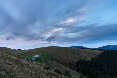 Dağlarda sabah manzarası. Dağlarda şafak vakti. Dağın tepesindeki kır kulübelerinde. Köyün üzerinde bulutlu bir gökyüzü. Ukrayna 'daki dağlar.