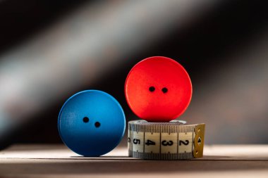 Çeşitli düğmeler ve dikiş sayacı. Kırmızı ve mavi düğme. Büyük ahşap düğmeler. Kompozisyon dikiyorum. Ön görünüm.