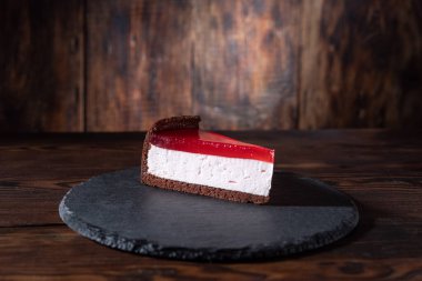 Kırmızı marmelatlı cheesecake. Tahta tepside kek. Marmelatlı kek. Ahşap arkaplan.