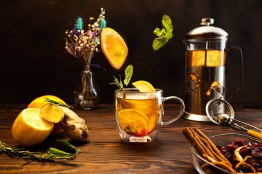 Çay kompozisyonu. Bileşenlerin havalanması. Şeffaf çay fincanı. Uçan nane ve limon dilimleri. Ön görünüm.