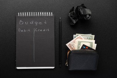 Finance and budgeting. Budget calculation. Black notebook and money. View from above. clipart