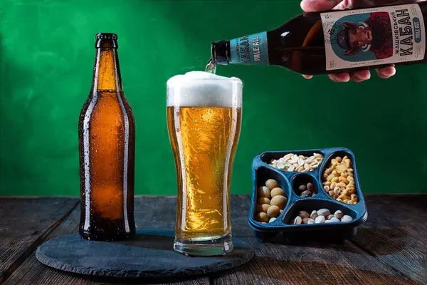 KYIV, UKRAINE - 30 Mayıs. 2022 Ukrayna birası cam bir şişede. Ukrayna 'dan açık bira. Taze bira ve atıştırmalıklar..